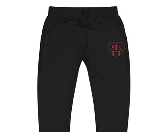 Può includere: Pantaloni della tuta neri con vita con coulisse e grafica a forma di cuore rosso sulla coscia sinistra. La grafica contiene caratteri giapponesi. I pantaloni della tuta hanno tasche e caviglie a coste.