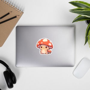 May include: A cute cartoon mushroom with a red and white cap and a small, smiling face. The mushroom is holding a smaller mushroom in its hand.