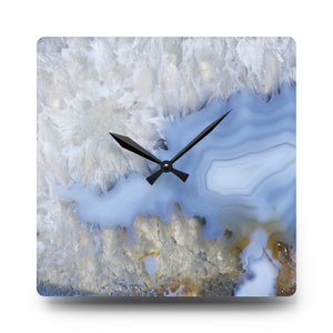 May include: Square wall clock with black hands and a blue and white agate stone design.