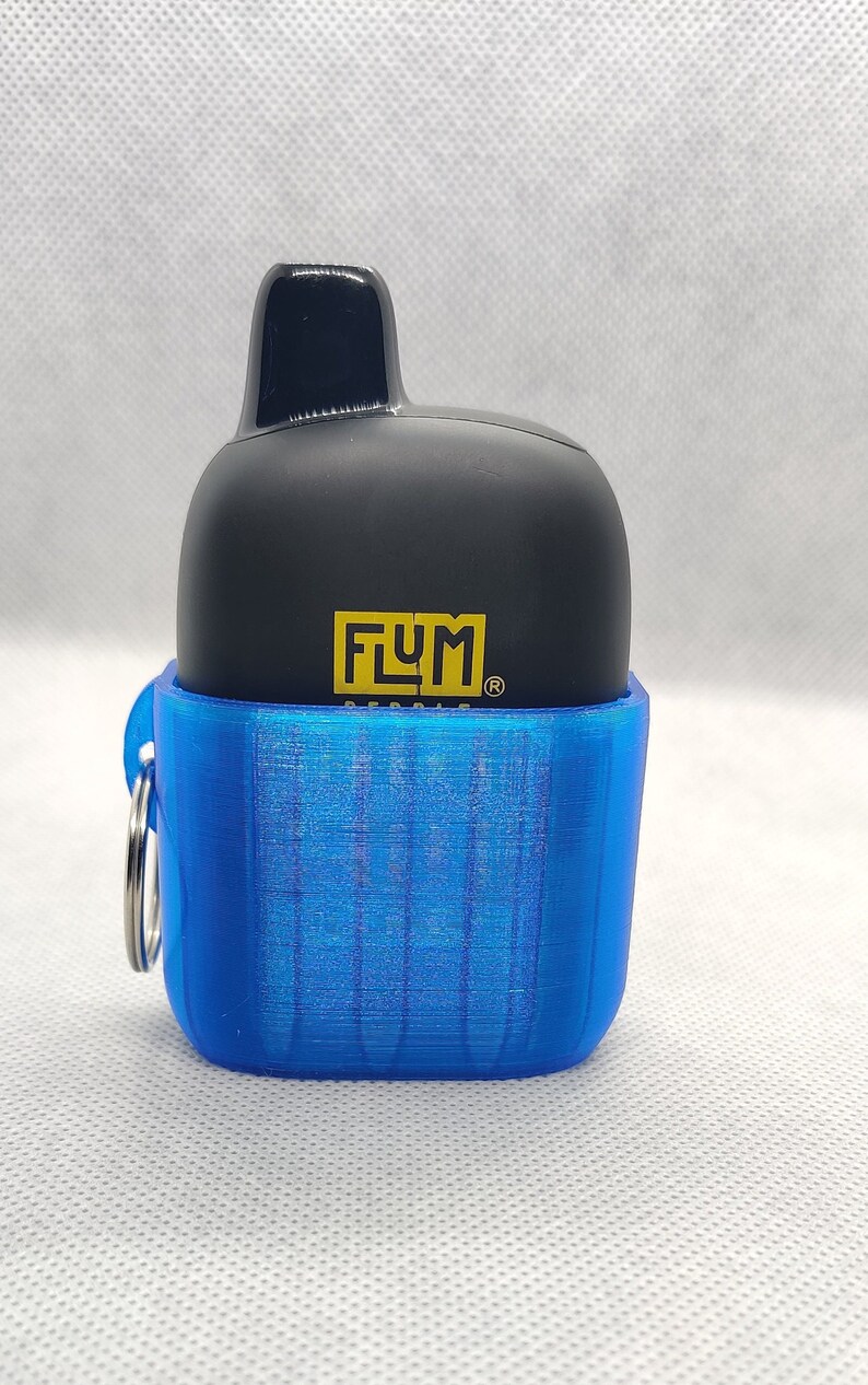 May include: A blue and black portable vape device with a keychain. The device has the word "FLUM" printed on it.