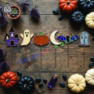 May include: A set of six stained glass Halloween plant stakes featuring a purple haunted house, a cream ghost, an orange pumpkin, a crescent moon, a blue bat, and a grey tombstone with the text R.I.P. each on a thin metal rod.
