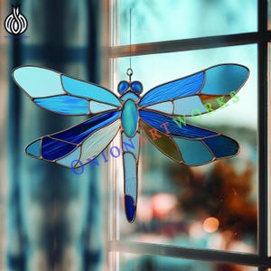 May include: Stained glass dragonfly in shades of blue, with a copper-colored frame. The dragonfly has detailed wings and body, hanging in front of a window. The dragonfly is a decorative art piece.