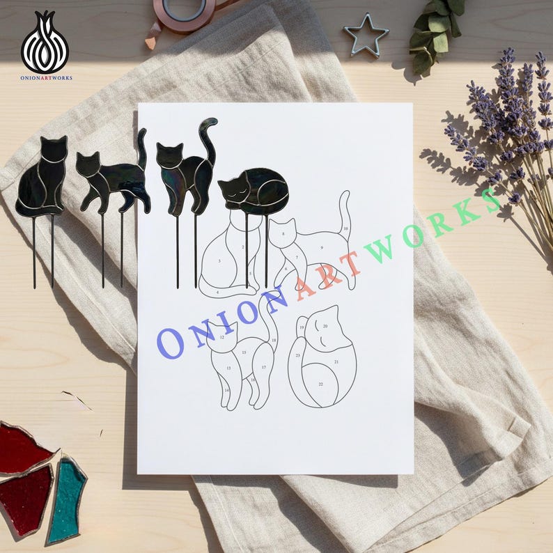 May include: A white paper pattern sheet featuring numbered outlines of four different cat shapes, accompanied by three finished black stained glass cat figures on metal stakes, each displaying a smooth, reflective surface and distinct feline poses.