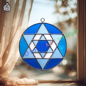 May include: A stained glass window hanging with a Star of David design. The window features a circular shape with a blue and white geometric pattern. The text "ONION ART WORKS" is visible on the glass.