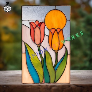 Puede incluir: Panel de vidrieras con dos tulipanes en tonos naranja, rojo y verde. La obra de arte incluye el texto "ONION ART WORKS". El panel es rectangular y está enmarcado en un marco oscuro.