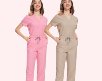 May include: Two women's scrub sets, one pink and one beige, with short sleeves and drawstring pants. The scrubs have a v-neck and a pocket on the left chest.
