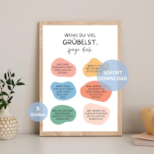 May include: A framed print with the German text "WENN DU VIEL GRÜBELST, frage dich" and several questions in colorful speech bubbles. The print includes the words "SOFORT DOWNLOAD" and "5 Größen". The frame is a light wood color.