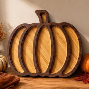 May include: A pumpkin-shaped serving tray crafted from two-toned wood, featuring a dark brown outer frame and a lighter, natural-colored bamboo interior with distinct vertical segments that mimic the ridges of a pumpkin.