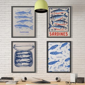 Puede incluir: Cuatro láminas enmarcadas con ilustraciones de sardinas azules y blancas. Una lámina muestra sardinas en lata, otra un patrón de peces y otras dos sardinas apiladas. La palabra "Sardinas" está impresa en dos de las láminas. Los marcos son negros.