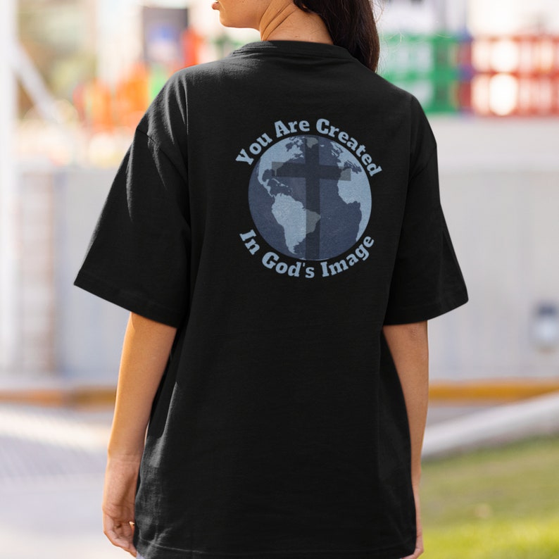 May include: Black t-shirt with a graphic of a globe with a cross on it. The text "You Are Created In God's Image" is printed around the globe.