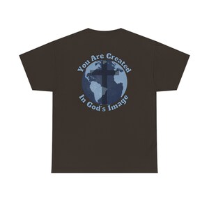 May include: A brown t-shirt with a blue and white graphic of a cross over a globe. The graphic says "You Are Created In God's Image".