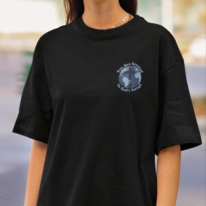 May include: Black t-shirt with a graphic of a globe with a cross on it. The text "You Are Created In God's Image" is written around the globe.