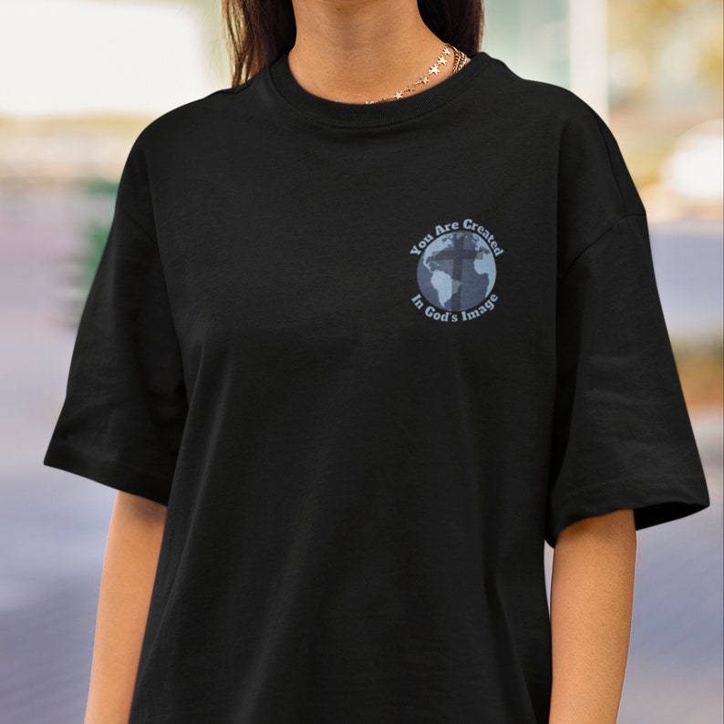 May include: Black t-shirt with a graphic of a globe with a cross on it. The text "You Are Created In God's Image" is written around the globe.