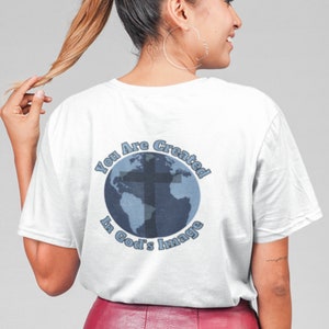 May include: White t-shirt with a blue and gray graphic of a globe with a cross on it. The text "You Are Created In God's Image" surrounds the globe.
