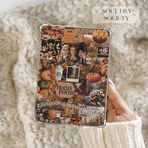 May include: A clear tablet case featuring a collage of autumn-themed imagery, including pumpkins, fall foliage, and characters from Hocus Pocus. The design includes text such as Spooky Szn, Hocus Pocus, and it's spooky season, with warm orange and brown tones.