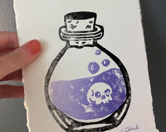 Könnte beinhalten: Ein Schwarz-Weiß-Druck einer Zaubertrankflasche mit einem Totenkopf im Inneren. Der Trank ist lila, und die Flasche ist mit einem Korken verschlossen. Der Druck befindet sich auf strukturiertem weißem Papier, mit der Editionsnummer 2/2 und der Signatur des Künstlers.