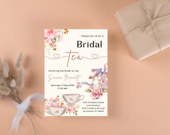Puede incluir: Una invitación a una fiesta de té de novia rosa y blanca con diseños florales de acuarela. La invitación presenta una tetera, tazas de té y el texto "Por favor, únase a nosotros para un té de novia en honor a la futura novia Suenna Bennett Sábado, 17 de mayo de 2025 11:00 AM Park Chateau Estate and Gardens 678 Cranbury Rd, East Brunswick, NJ 08816".