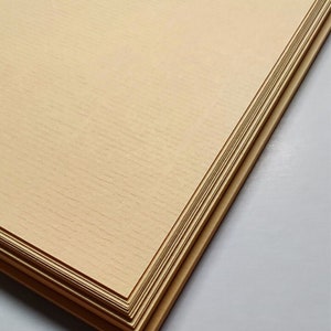 K&ouml;nnte beinhalten: Ein Stapel Conqueror Laid Orange Papier, 100 g/m&sup2;. Das Papier ist hellorange und hat eine leicht strukturierte Oberfl&auml;che.