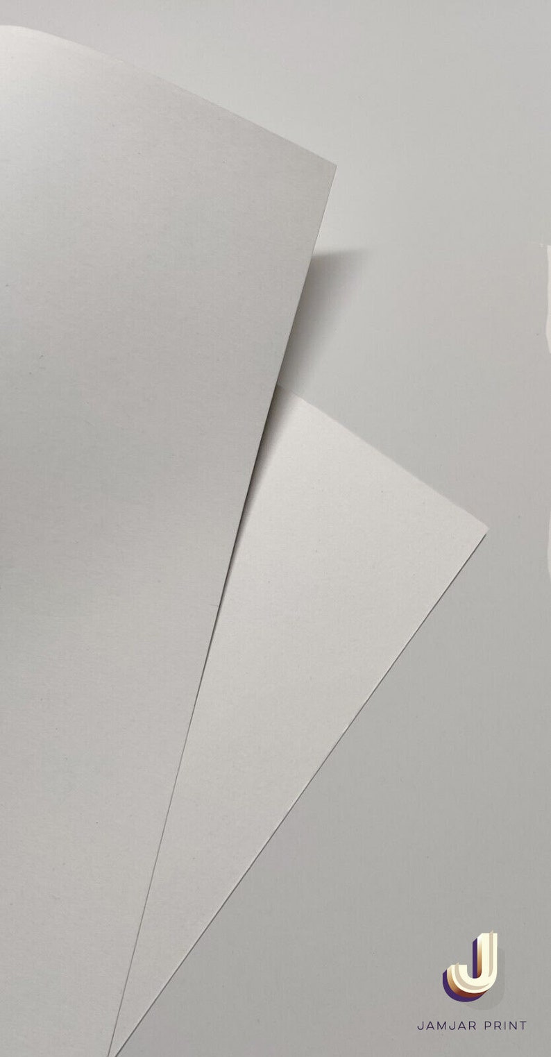 May include: Two sheets of white paper, one on top of the other, with the top sheet folded over to create a triangular shape. The bottom sheet is slightly visible underneath. The image has a white background and the text "JAMJAR PRINT" in the bottom right corner.
