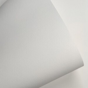 K&ouml;nnte beinhalten: Nahaufnahme eines wei&szlig;en, strukturierten Papierblattes. Das Papier ist mit "Conqueror Laid High White 100gsm" beschriftet und hat eine subtile, gepr&auml;gte Textur. Das Papier ist &uuml;ber sich selbst gefaltet und zeigt die wei&szlig;e Unterseite.