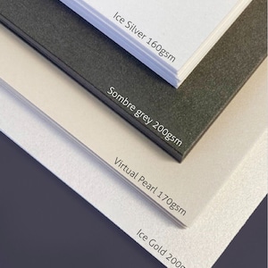 May include: Four sheets of pearlescent craft shimmer card stock in different colours and weights. The colours are Ice Silver, Sombre Grey, Virtual Pearl, and Ice Gold. The weights are 160gsm, 200gsm, 170gsm, and 200gsm. The card stock is A4 size.