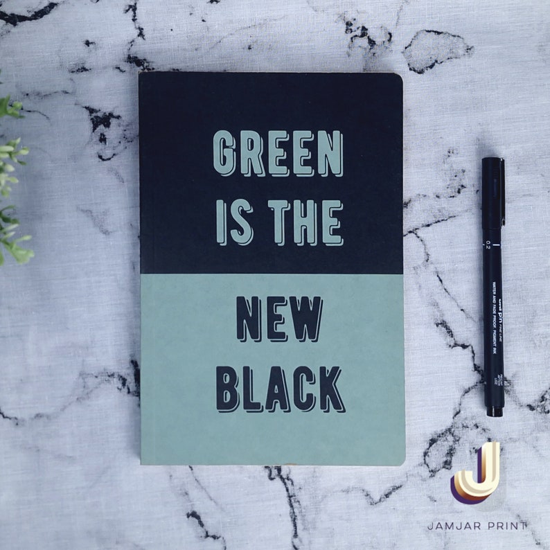 Może przedstawiać: Czarny i zielony notes z tekstem "GREEN IS THE NEW BLACK" na okładce.