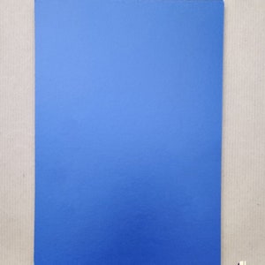 Puede incluir: Una hoja de papel azul s&oacute;lido. El papel es liso y tiene un ligero brillo.