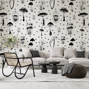 May include: A living room interior with a white sofa, a black chair, and two black side tables. The wall is covered in a black and white wallpaper featuring a repeating pattern of mushrooms and stars.