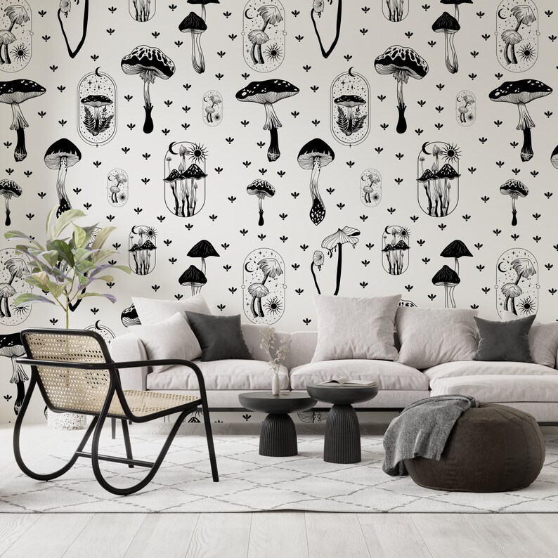 May include: A living room interior with a white sofa, a black chair, and two black side tables. The wall is covered in a black and white wallpaper featuring a repeating pattern of mushrooms and stars.