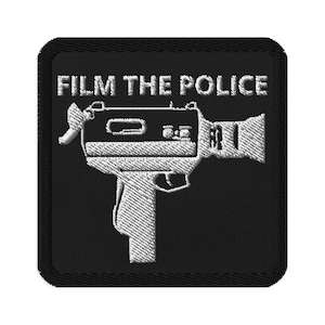 Puede incluir: Parche bordado en blanco y negro con una cámara de video vintage y el texto "FILM THE POLICE".