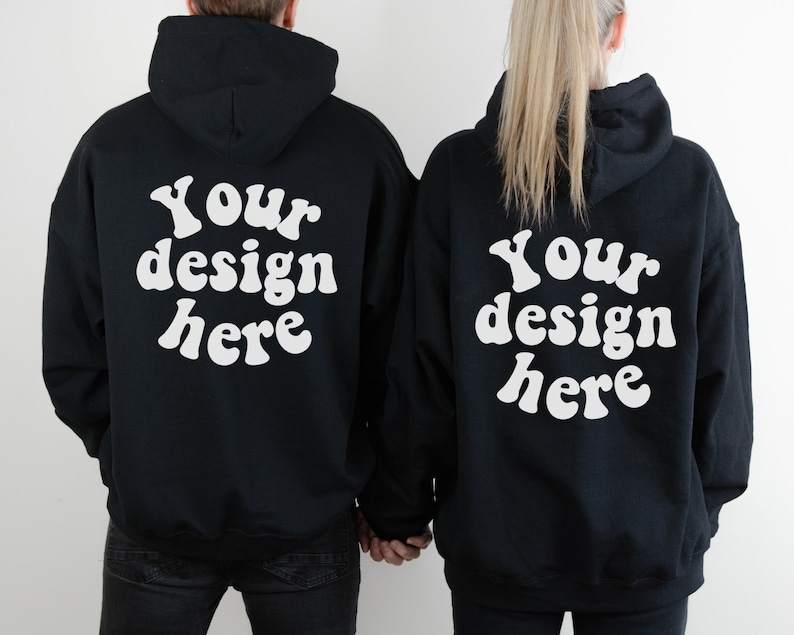May include: Two black hoodies with white text on the back that says "Your design here" in a retro font.
