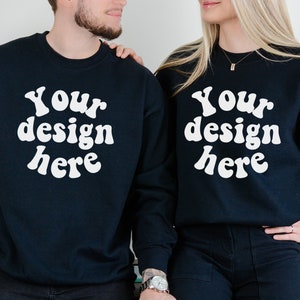 May include: Two black sweatshirts with the text "Your design here" in white, retro-style font. The sweatshirts are worn by two people standing side-by-side.