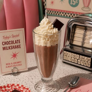 May include: A chocolate milkshake in a clear glass, topped with whipped cream and a chocolate square. A sign reads "Today's Special CHOCOLATE MILKSHAKE RICH & CREAMY! ALWAYS DELICIOUS". A retro diner scene with a jukebox and a plate of chocolate.