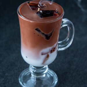 May include: A glass of iced chocolate with chocolate ice cubes and steam rising from the top.