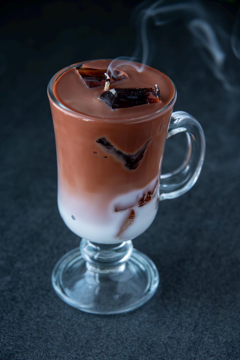 May include: A glass of iced chocolate with chocolate ice cubes and steam rising from the top.