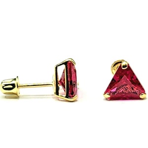 May include: A pair of gold earrings with red triangular gemstones. The earrings have a screw-back closure.