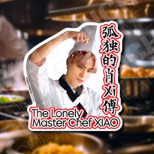 May include: A sticker featuring a person in a chef's uniform and hat. The text "The Lonely Master Chef XIAO" is below the image, with Chinese characters on the right side. The background is a blurred kitchen scene.
