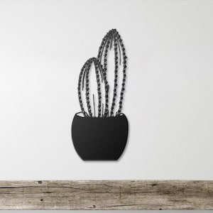 May include: A white ceramic mug with a black handle and the text "But First, Coffee" in a bold, black font. The mug is sitting on a wooden surface. The mug is approximately 4 inches tall.