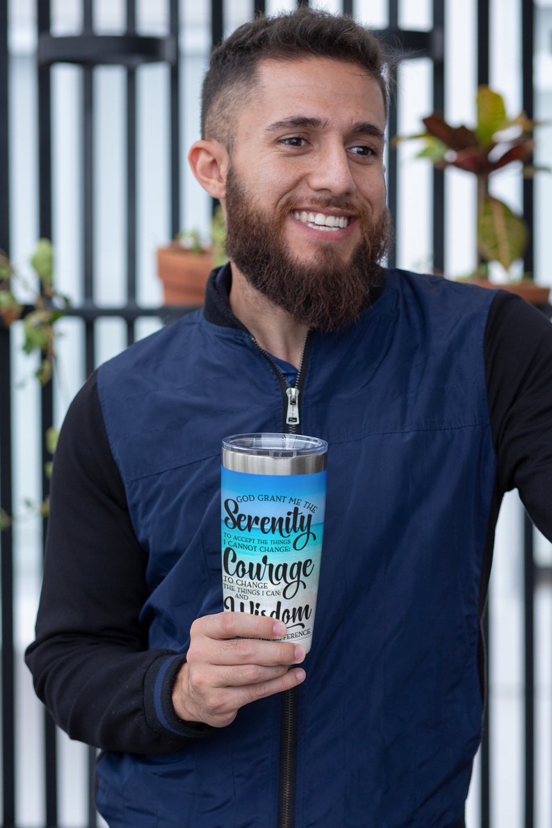 May include: A stainless steel tumbler with a blue and white design. The tumbler features the text "God grant me the Serenity to accept the things I cannot change. Courage to change the things I can. And Wisdom to know the difference."