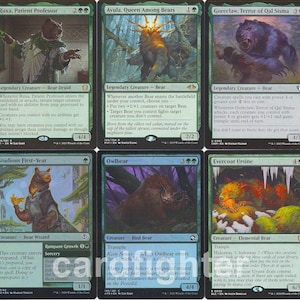 May include: A collection of ten Magic: The Gathering trading cards arranged in two rows of five. The cards feature green and blue borders with various fantasy illustrations of bears, druids, and nature scenes, including text and symbols.