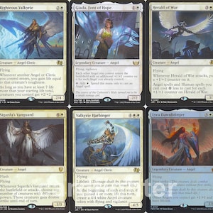 May include: A collection of ten Magic: The Gathering trading cards arranged in two rows of five. Each card features unique fantasy artwork of angels and warriors, with detailed text boxes, mana symbols, and power/toughness stats printed on white borders.