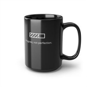 Op de afbeelding: Zwarte keramische koffiemok met een witte voortgangsbalk-afbeelding en de tekst "Progress, not perfection."