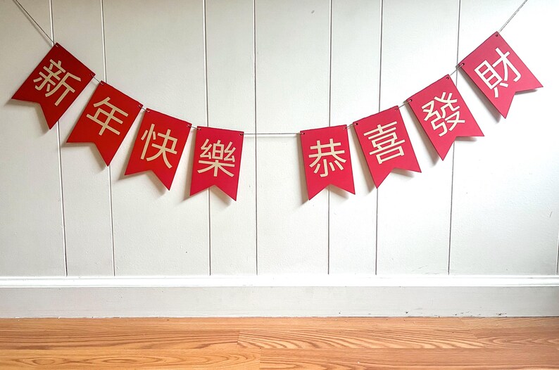 May include: Red Chinese New Year banner with the text "新年快乐恭喜发财" which translates to "Happy New Year, Good Luck, and Prosperity"