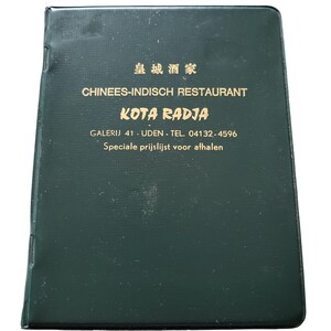 Op de afbeelding: Een donkergroene menucover met gouden letters. De tekst luidt "皇城酒家 CHINEES-INDISCH RESTAURANT KOTA RADJA GALERIJ 41 - UDEN - TEL. 04132-4596". Het menu is voor een Chinees-Indisch restaurant.
