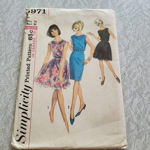 Puede incluir: Patrón de costura Simplicity impreso 65c, un patrón de costura vintage para un vestido. El patrón muestra tres estilos de vestidos diferentes: un vestido de estampado floral, un vestido azul con cinturón y un vestido negro con ribete de encaje. El patrón es para la talla 16, busto 36.