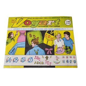 May include: A vintage Vogart transfer pattern packet with the text "new fashion" and "REPEAT TRANSFER PATTERNS." The cover features illustrations of embroidered designs, including letters and floral patterns, on clothing and accessories.