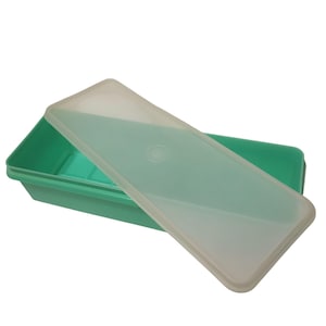 May include: A rectangular, teal-colored plastic container with a translucent lid. The lid is slightly ajar, revealing the interior of the container. The container is designed for storage and organization, suitable for various household items.