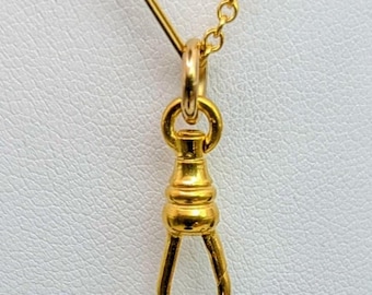 May include: A gold-toned metal swivel dog clip pendant featuring a rounded, tapered body with a hinged spring-loaded gate mechanism. The pendant is suspended from a gold-toned chain link, with the text The Chain is Not Included printed below.