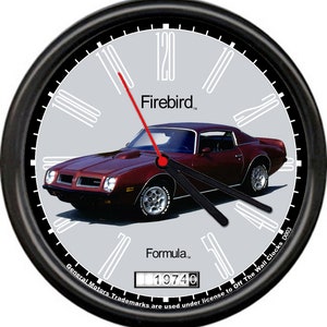 May include: A black wall clock with a red second hand and a burgundy 1974 Pontiac Firebird Formula car on the face. The clock face has white Roman numeral hour markers and black minute markers. The clock face also has the text "Firebird", "Formula", "General Motors Trademarks are used under license to Off The Wall Clocks D003", and "19740".