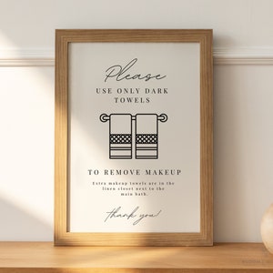 May include: A framed sign with the text "Please use only dark towels to remove makeup. Extra makeup towels are in the linen closet next to the main bath. Thank you!"